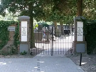 Het toegangshek met een spreuk op de zuilen