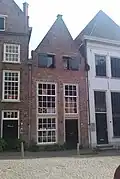Huis met gepleisterde tuitgevel, moderne werkplaatsdeur