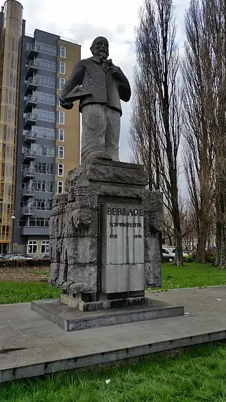 Standbeeld Berlage met op de achtergrond de 12-verdiepingenflat (maart 2019)