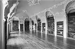 C en S-vormige voluten vormen cartouches tussen de nissen.