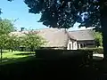 Boerderij onder met riet en pannen gedekt wolfsdak, thans een bibliotheek