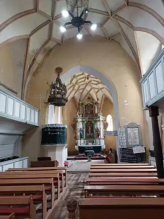 Interieur van de kerk gezien naar het koor toe met links de preekstoel