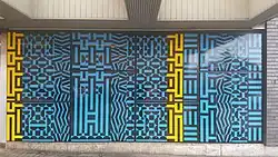 De gevelbekleding naast de ingang.