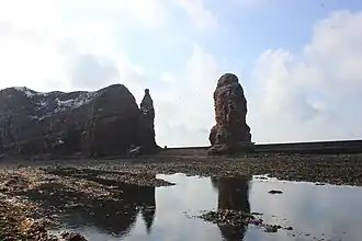 Uitzicht op de rotswadden van de Helgoländer Felssockel en de bontzandsteenkliffen van Helgoland, inclusief de "Lange Anna".