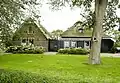 Boerderij van het Westfriese stelptype, in oorsprong op een terp gesitueerd, met uitgebouwd voorhuis onder pannen zadeldak, met licht overstek, boeiborden en spaakvormige bekroning met makelaar, en met bedrijfsgedeelte onder rieten stolpdak, met pannen rand onderlangs