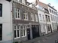Huis met brede lijstgevel en een poort.