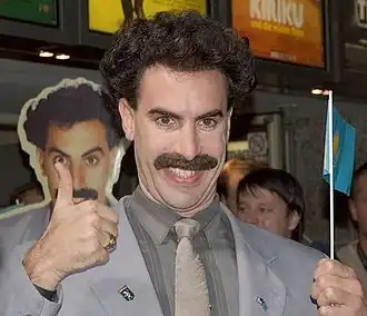 De fictieve journalist Borat Sagdiyev, hoofdpersoon van de mockumentary Borat: Cultural Learnings of America for Make Benefit Glorious Nation of Kazakhstan (2006) in actie.
