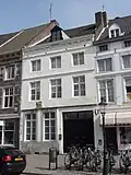 Huis, waarvan de gevel in de trant der zgn. Maaslandse renaissance eindigt in een hoofdgestel met consoles. Gevelsteen IN DEN LUYPAERD, afkomstig van Vrijthof 9.