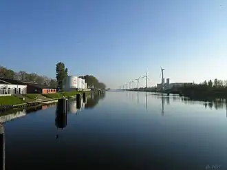 Het Boudewijnkanaal met rechts de schoorstenen van Herdersbrug