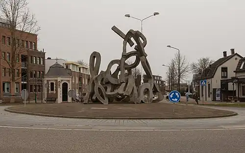 Boxmeer, sculptuur op rotonde Spoorstraat-Steenstraat met Sint-Rochuskapel op de achtergrond