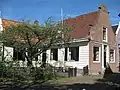 Houten huis met bakstenen halsgevel uit 1768 en houten puntgevel aan zijkant