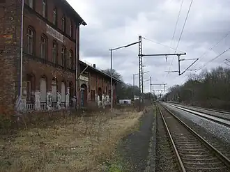 Het oude stationsgebouw en in de verte het huidige perron
