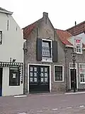 Huis met puntgeveltje met vlechtingen