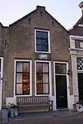 Huis met puntgevel met schuiframen en stoep