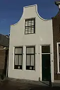 Huis met gepleisterde tuitgevel met stoep