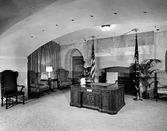 zwart-wit afbeelding van het Resolute bureau in de uitzendkamer van het Witte Huis