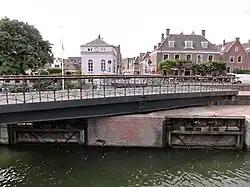 Geopende brug met witgepleisterde sluiswachterswoning