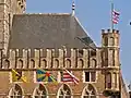Twee vlaggen van de stad Brugge aan het Brugse belfort, samen met een vlag van West-Vlaanderen en een vlag van Vlaanderen.