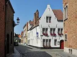 De Grauwwerkersstraat in noordwestelijke richting gezien, met centraal in beeld het 16de-eeuwse hoekhuis Pieter Pourbusstraat 1 (beschermd monument)