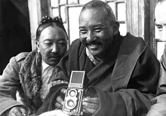 Möndro met een fotocamera, 1938, met Kyibu op de achtergrond