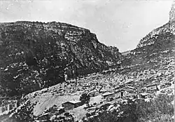 De bouwplaats met onderkomens, links in beeld de voeten van de pijlers in aanbouw.