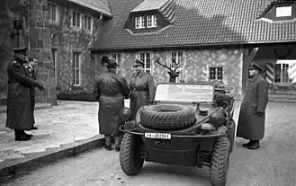 Hermann Göring begroet een leider van de SS in de tuin van Carinhall, op de achtergrond het bronzen hert.