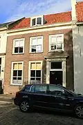 Huis met verdieping en zadeldak, evenwijdig aan de straat. De in een steentje gedateerde lijstgevel heeft een eenvoudige deuromlijsting met pilasters en hoofdgestel, waarin een deur uit de bouwtijd van de gevel en vensters met hardstenen dorpels en zes- en vierruitsramen