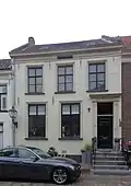 Pand, onderkelderd en met verdieping, gedekt door een zadeldak tussen topgevels, evenwijdig aan de straat