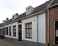 Dwarshuis met zadeldak, vermoedelijk gebouwd op de stadsmuur