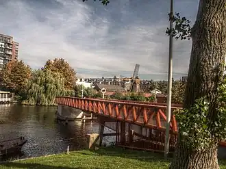 De Buysbrug over het Oostelijk Marktkanaal, gezien vanaf de Jan van Galenstraat met op de achtergrond molen De Otter in de Gilles van Ledenberchstraat. 3 oktober 2013