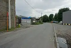 Uplace-site in Machelen, de poort staat nog steeds schuin op de straat, d.i. loodrecht op de voormalige spoorwegtoegang. In 2022 is de rails nog te zien; de rest, links, is verdwenen.