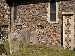 De noordmuur aan de buitenkant. De rode stenen zijn afkomstig van Romeinse bouwwerken en de oudste stenen van het gebouw