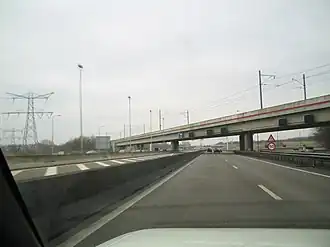 De Flevolijn ging tot augustus 2016 met dit viaduct over de A1. In het weekend van 20 en 21 augustus 2016 is deze gesloopt en vervangen door de Zandhazenbrug.