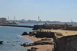 Zicht vanaf het kasteel op Cádiz met in de verte links de pijlers van de Puente de la Constitución de 1812 en uiterst rechts een van de twee hoogspanningsmasten van Cádiz