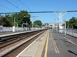De noordelijke spoorbak met perrons en bebording in de huisstijl van de Elizabeth line.