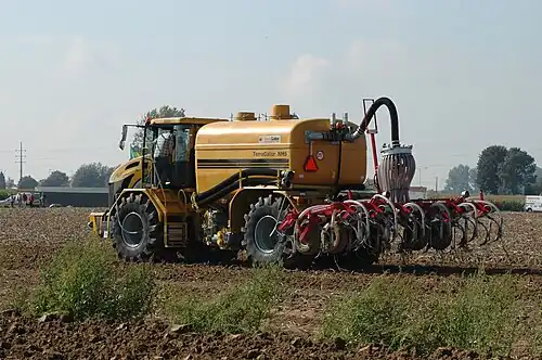 Zelfrijdende mesttank met twee assen met achterop een bouwlandbemester met tanden