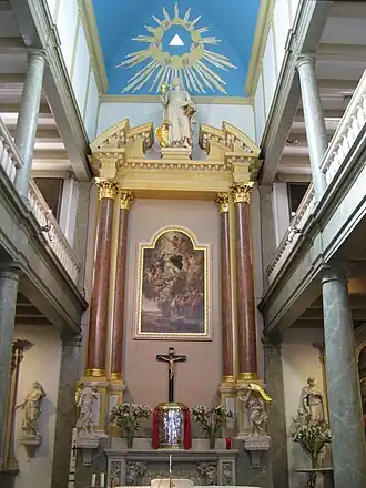Het hoogaltaar in de kapel. Boven het tabernakel hangt het schilderij dat de Tenhemelopneming van Maria voorstelt, en daarboven het beeld van de apostel Johannes, de patroon van de kapel. Links en rechts zijn de galerijen goed te zien. Zo konden er meer mensen in deze kleine ruimte de mis bijwonen.