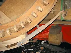 Detail bovenwiel met een voering van houten blokjes (belegstukken) van de Concordiamolen. De kammen bij de kruisarm zijn aan de voorkant geborgd met houten borgpennen.