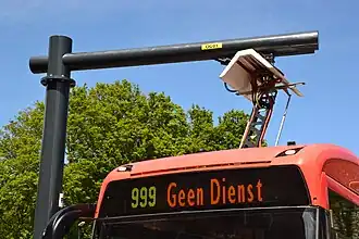 Pantograaf van elektrische bus met pantograaf aan laadstation.