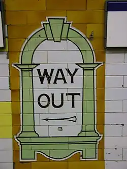 Cartouche met de wegwijzer naar de uitgang van het perron