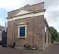 Langgerekt bakstenen gebouw onder schilddak