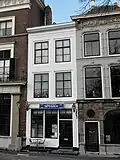 Huis met eenvoudige geverfde lijstgevel. Stoep