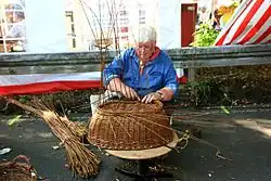 Mandenvlechtster op een Duitse ambachtenmarkt
