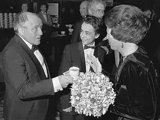 Johnny Kraaykamp biedt koningin Beatrix een kopje koffie aan. Marc van Uchelen staat in het midden. (Na de première van De Aanslag, 1986)