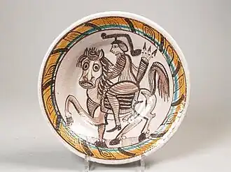 Schaal met decoratie van ruiter te paard in mangaan, geel en groen glazuur op grijs getint tinglazuur