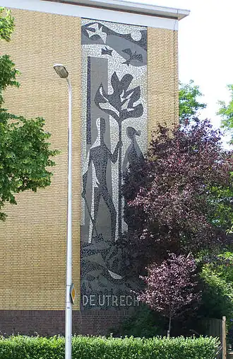 Mozaïek van het beeldmerk van Levensverzekering-maatschappij De Utrecht tegen een flatgebouw dat mede werd gebouwd door "De Utrecht".