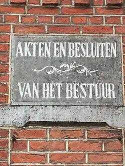 Arduinen gevelsteen met inscriptie: "Akten en Besluiten van het bestuur"