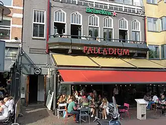 De ingang (links) en het balkon van sociëteit De Kring aan het Kleine-Gartmanplantsoen in Amsterdam
