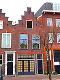 Bedrijfspand met bovenwoning, rond 1900 gebouwd in een sobere traditionalistische bouwtrant geïnspireerd op de ¿Oud-Hollandse¿ architectuur van rond 1600.