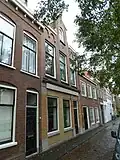 Woonhuis met voorgevel in 1899, ontworpen door C.J.L. Kersbergen in een traditionalistische bouwtrant met invloeden van de Nieuwe Kunst. Herplaatste oudere gevelsteen In de drie Swaenen; eind-16de-eeuws.